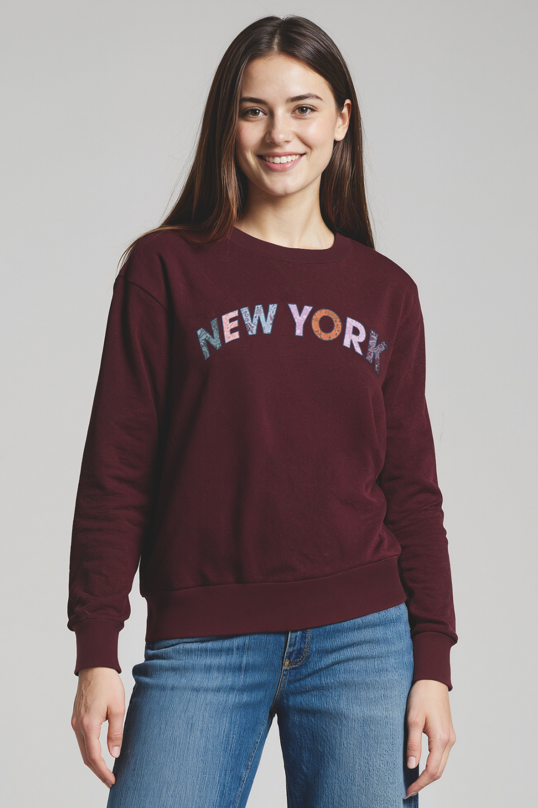 Woman wearing a maroon sweatshirt with &