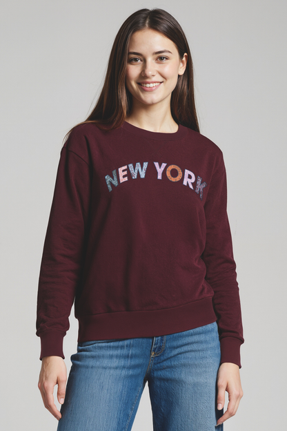 Woman wearing a maroon sweatshirt with &