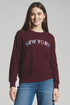 Woman wearing a maroon sweatshirt with &