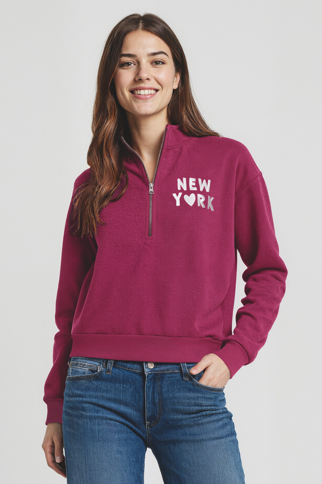 Woman wearing a magenta 1/2 zip pullover with &