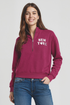 Woman wearing a magenta 1/2 zip pullover with &
