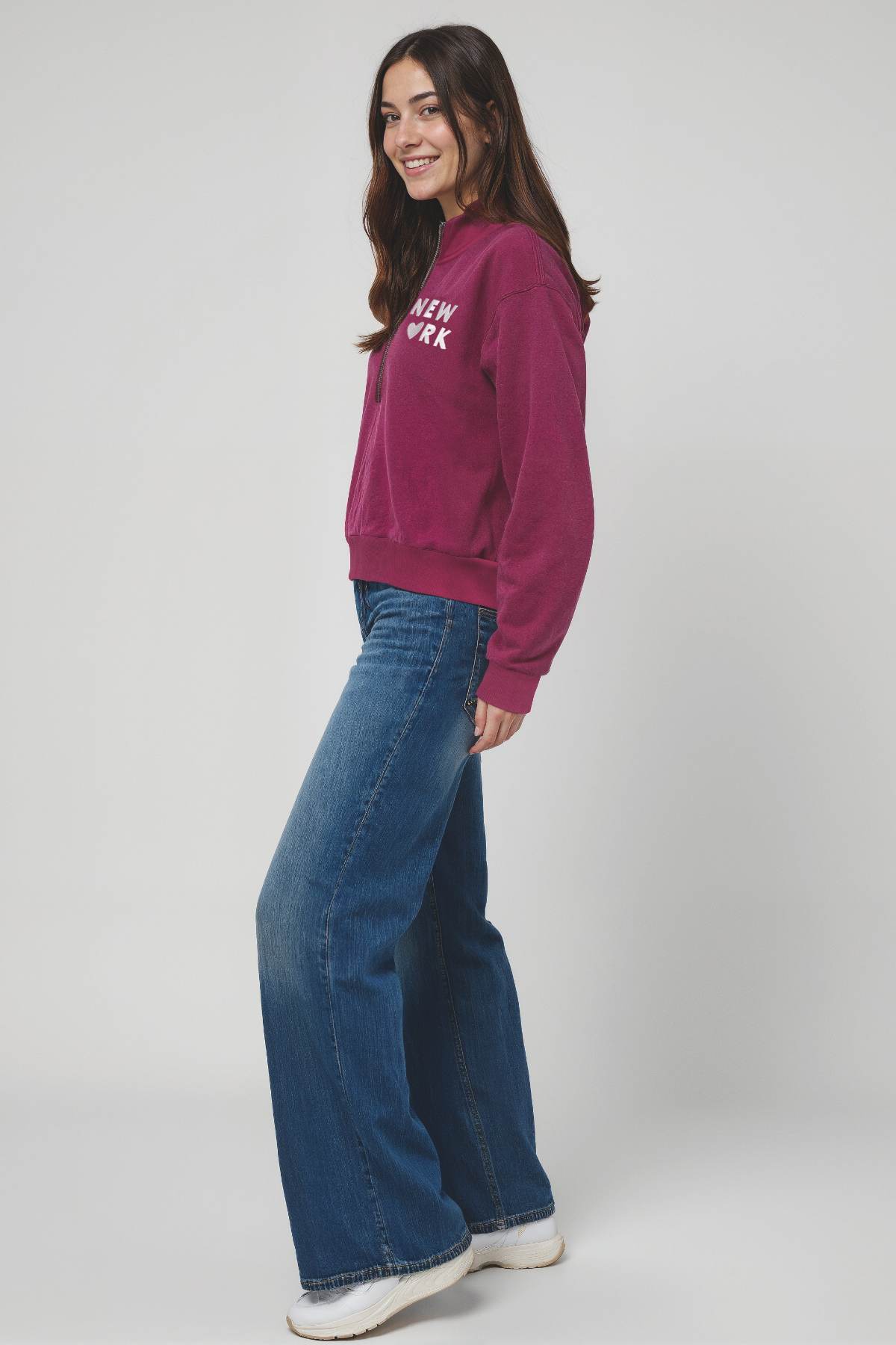 Woman wearing a magenta 1/2 zip pullover with &