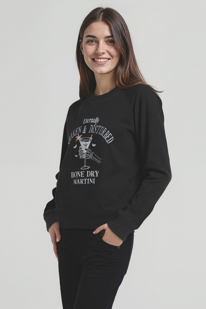 Woman wearing a black sweatshirt with white graphic design of a skeleton holding a martini glass and text &
