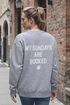 Woman wearing a gray sweatshirt with &