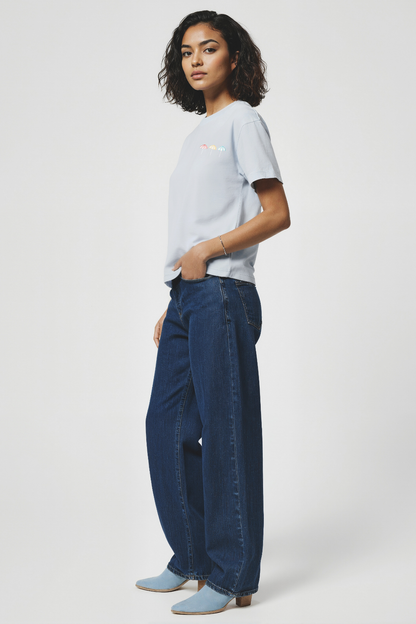 Woman wearing a light blue t-shirt and dark blue jeans on a white background