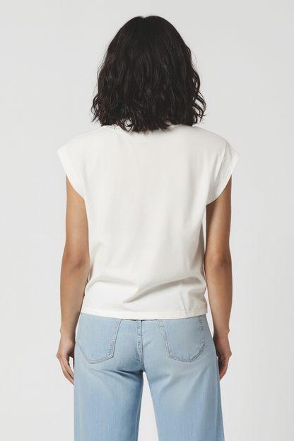 Back view of woman wearing a white t-shirt and light blue jeans on a plain background
