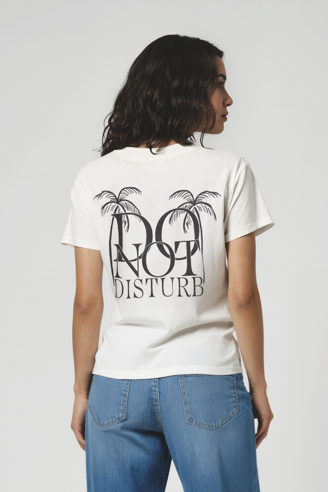 Back view of woman wearing a white t-shirt with &