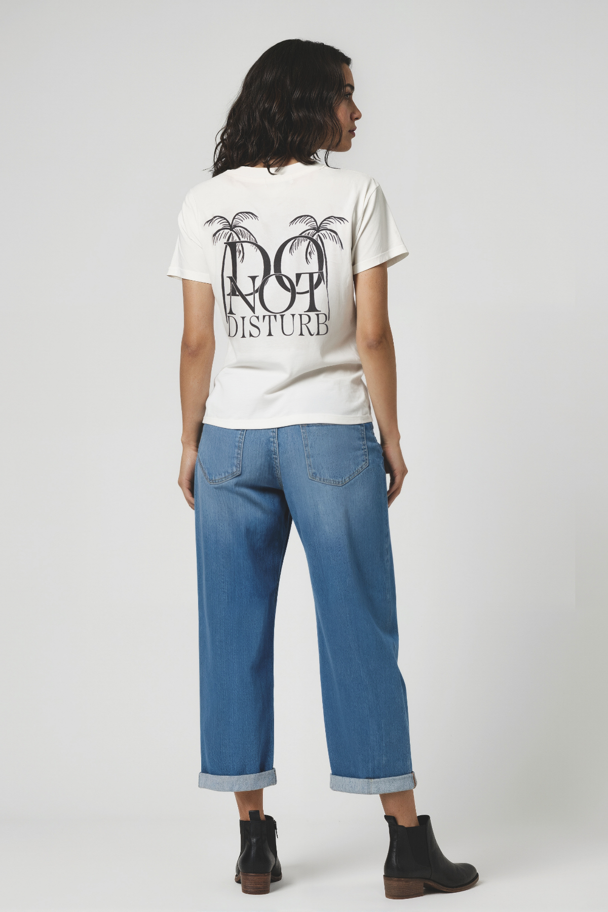 Back view of woman wearing a white t-shirt with &