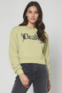 Woman wearing a light green sweatshirt with &