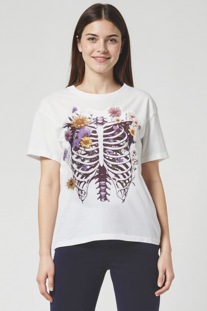 Woman wearing a white t-shirt with a floral skeleton ribcage design on a plain background