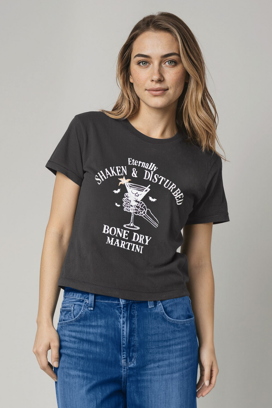 Woman wearing a black t-shirt with a skeleton hand holding martini glass graphic design and &