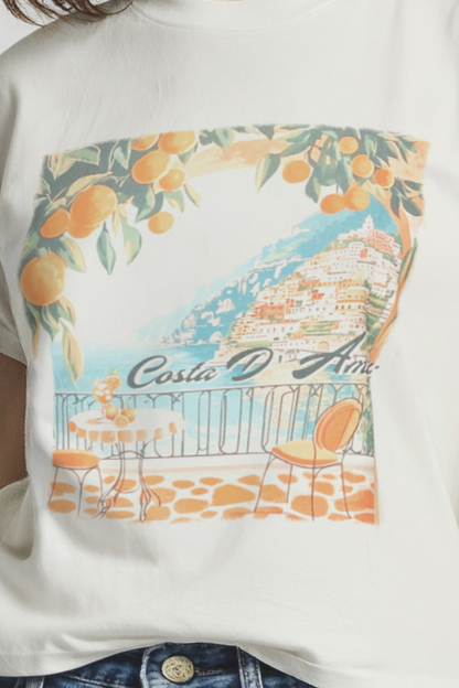 Close up of white t-shirt with a colorful graphic of a coastal scene and &