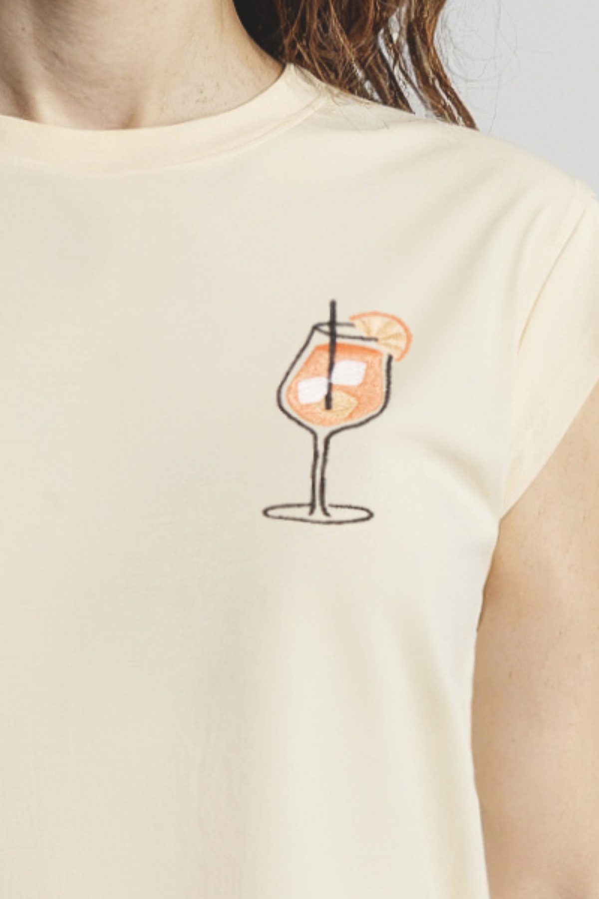 Close up of yellow front tank with a cocktail graphic worn by a woman