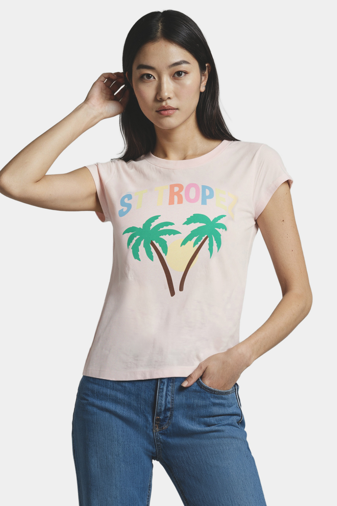 Woman wearing a pink t-shirt with palm trees and sun design and &