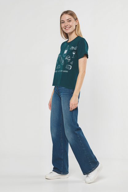 Woman wearing a teal t-shirt with white illustrations of cheese, wine, and bread, and text &