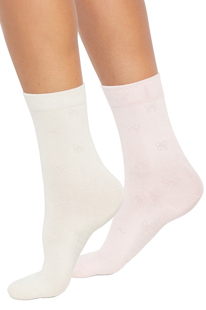 Two pairs of socks, one white and one pink, on a plain background.