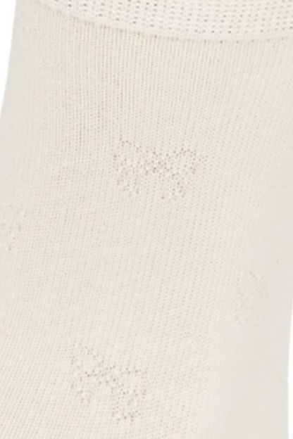 Close-up of a white sock with embossed bow textured print fabric.
