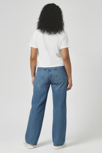 Back of woman wearing a light blue t-shirt and blue jeans on a white background