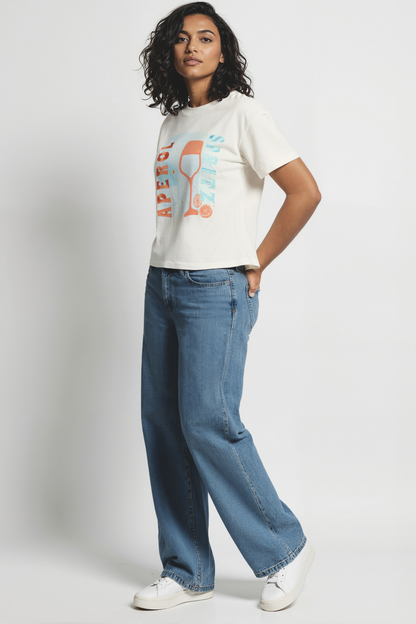 Woman wearing white t-shirt with a colorful graphic of a wine glass and &