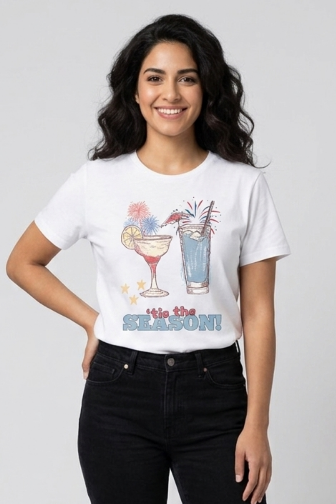 Woman wearing a white t-shirt with cocktail graphics and text on a plain background