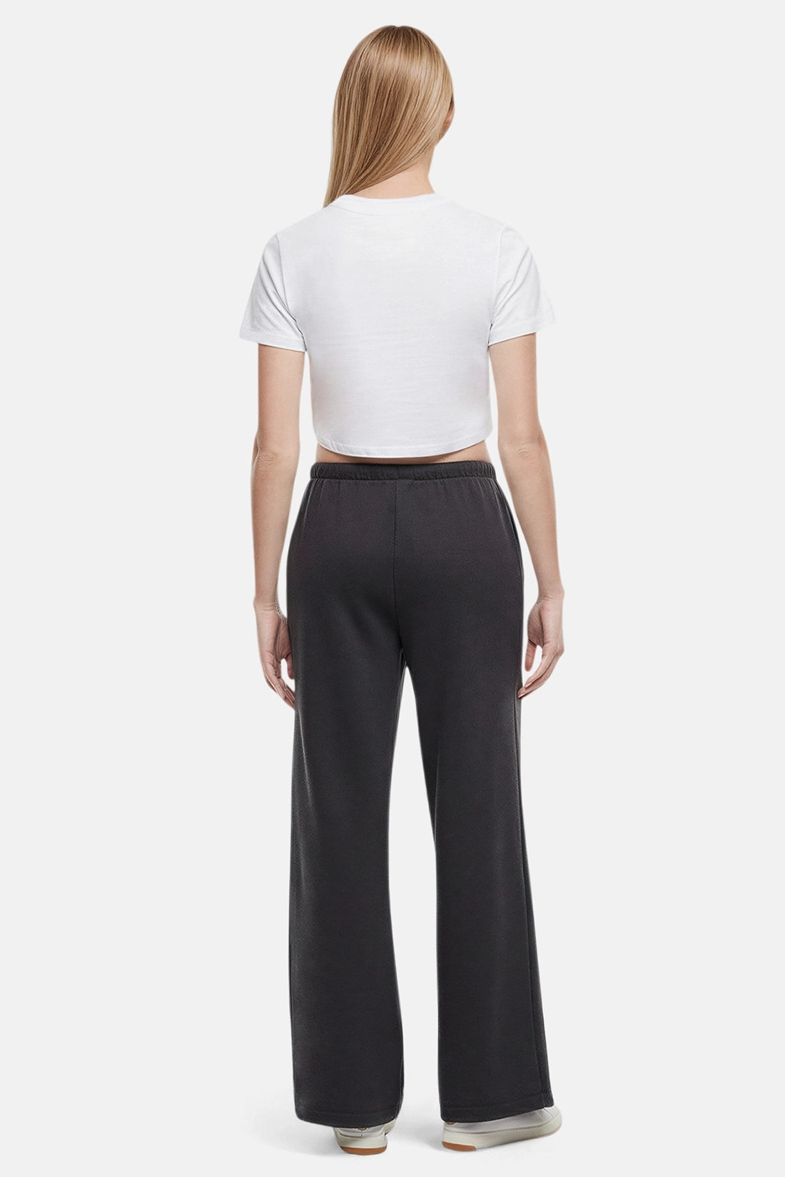 Back of woman wearing a white cropped t-shirt and heather black wide-leg drawstring sweatpants on a white background
