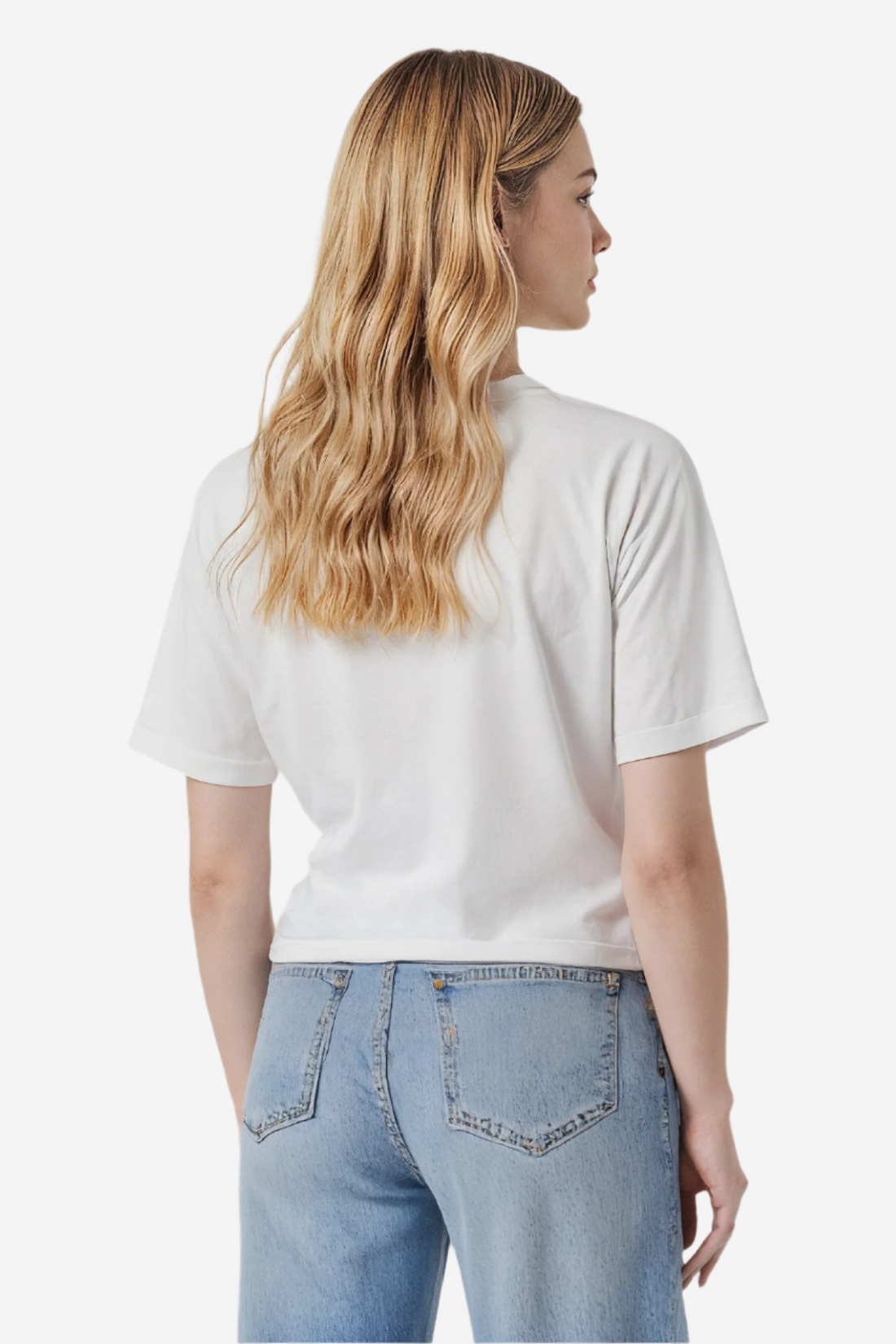 Woman wearing a white t-shirt and blue jeans on a plain background