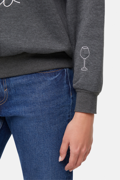 Gray sweatshirt with a white wine glass design above left hem sleeve on a plain background