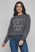 Woman wearing a gray sweatshirt with &