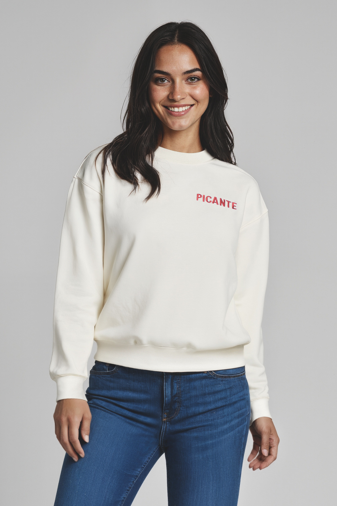 Woman wearing a white sweatshirt with &