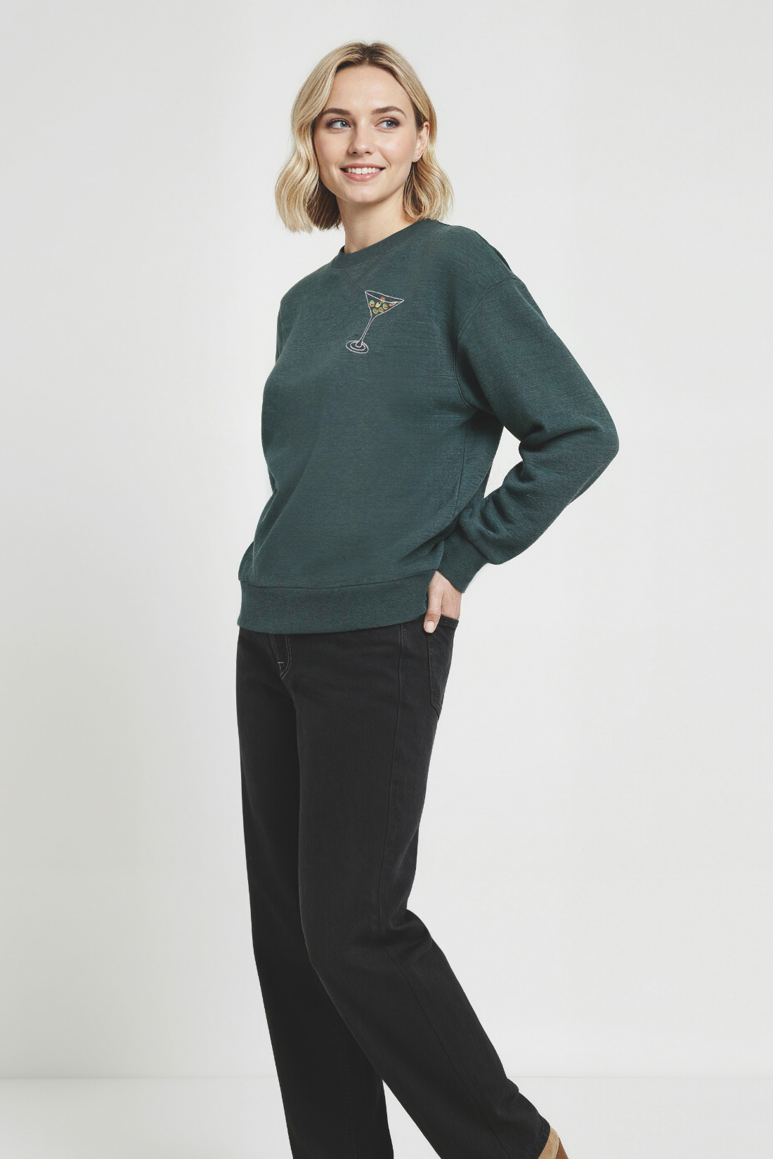 Woman wearing a green sweatshirt with a martini glass design on a white background