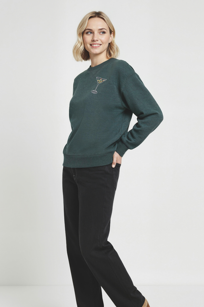 Woman wearing a green sweatshirt with a martini glass design on a white background
