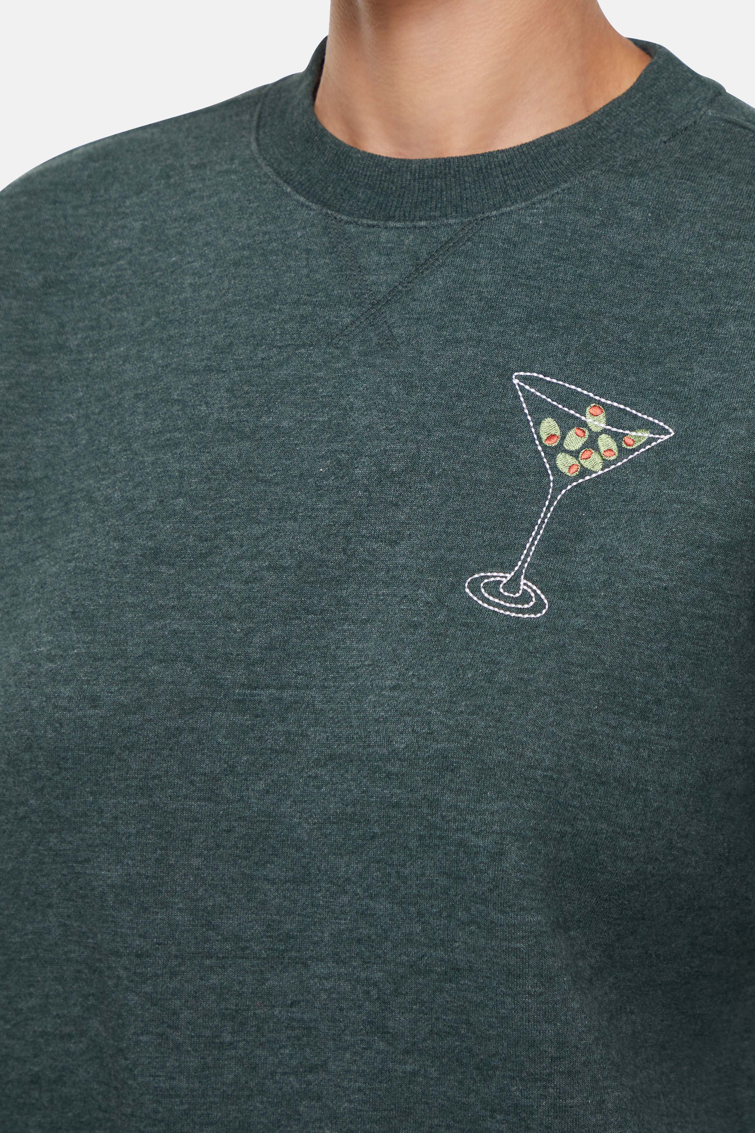 Close up of Green sweatshirt with a martini glass design on a plain background