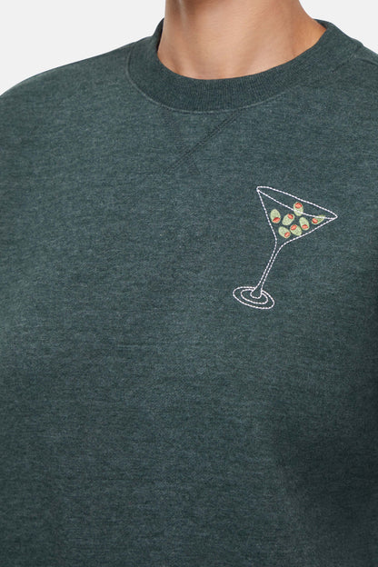 Close up of Green sweatshirt with a martini glass design on a plain background
