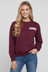 Woman wearing a maroon sweatshirt with &