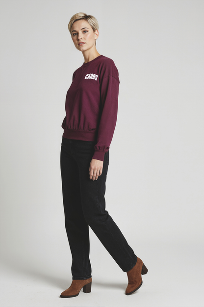Woman wearing a burgundy sweatshirt with &