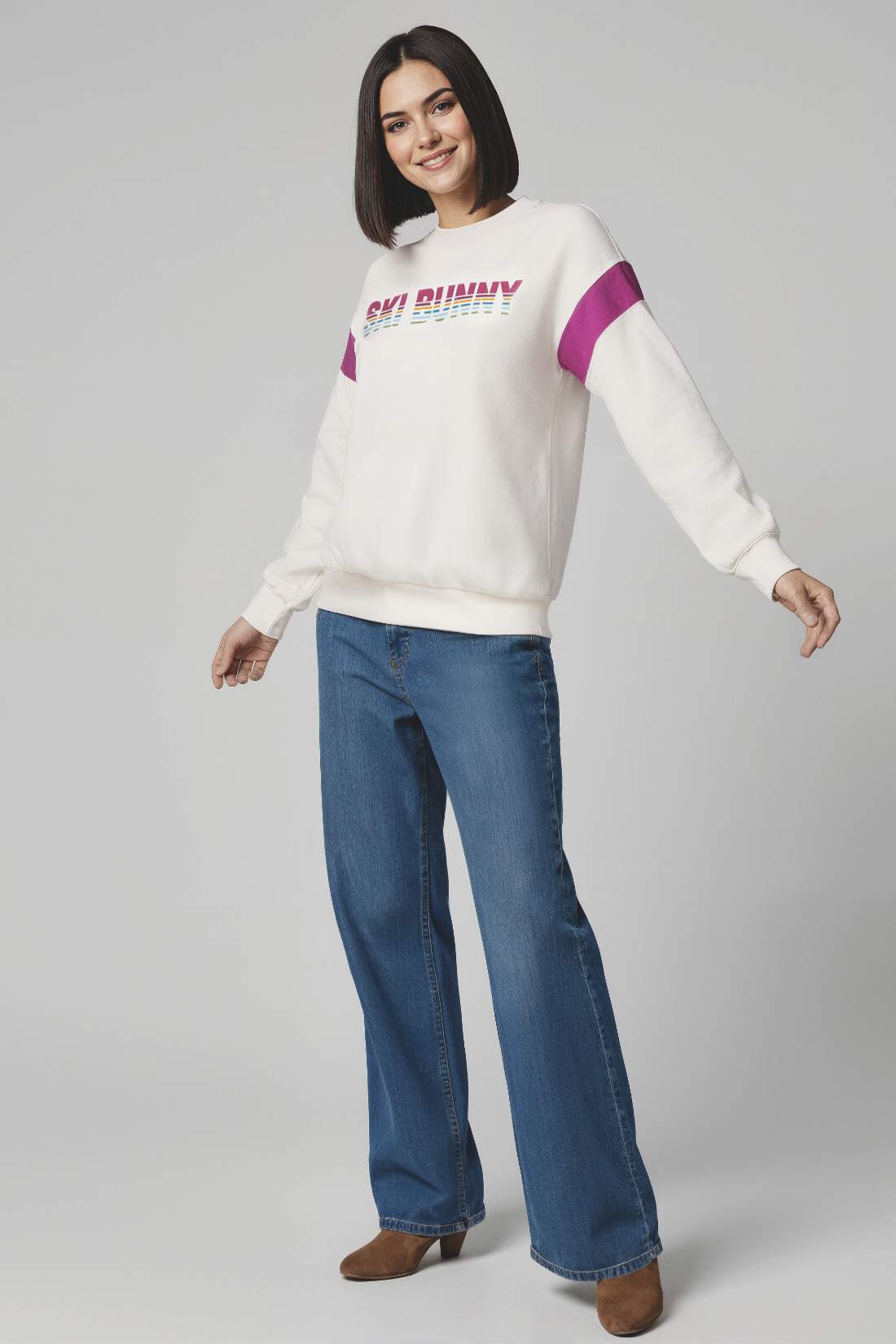 Woman wearing a white sweatshirt with colorful &