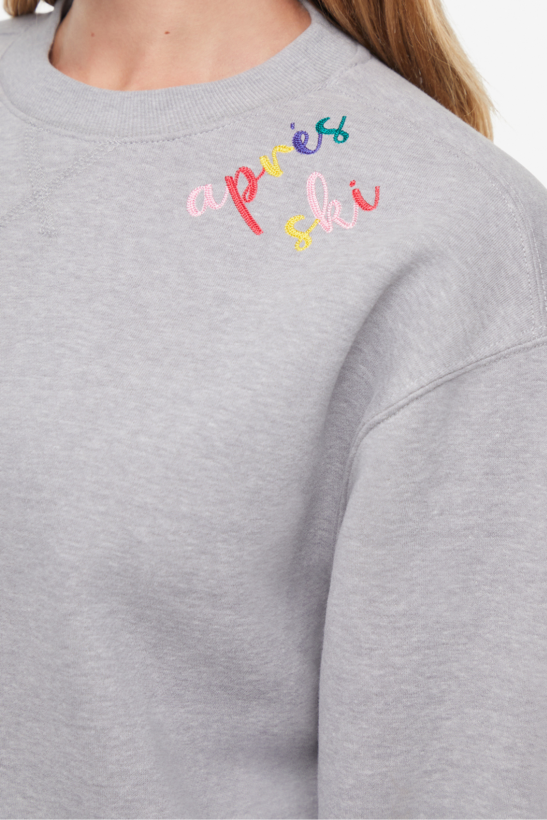 Close up of gray sweater with colorful embroidered &