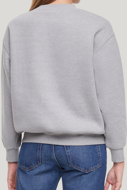 Back of woman wearing a gray sweatshirt on a plain background