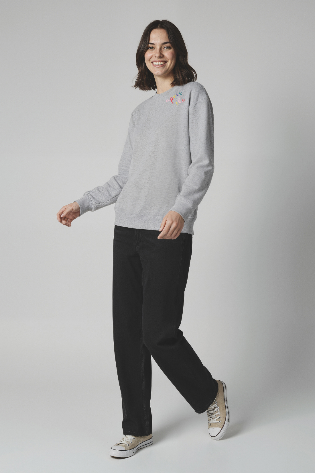 Woman wearing a gray sweatshirt with colorful &