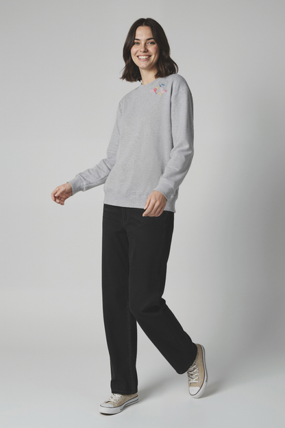 Woman wearing a gray sweatshirt with colorful &