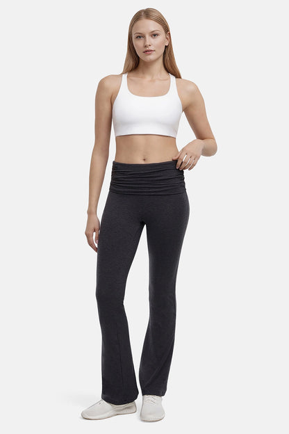 Woman wearing a white sports bra and black yoga pants on a white background