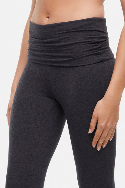 Close up of dark gray yoga pants worn by a woman n a light gray background