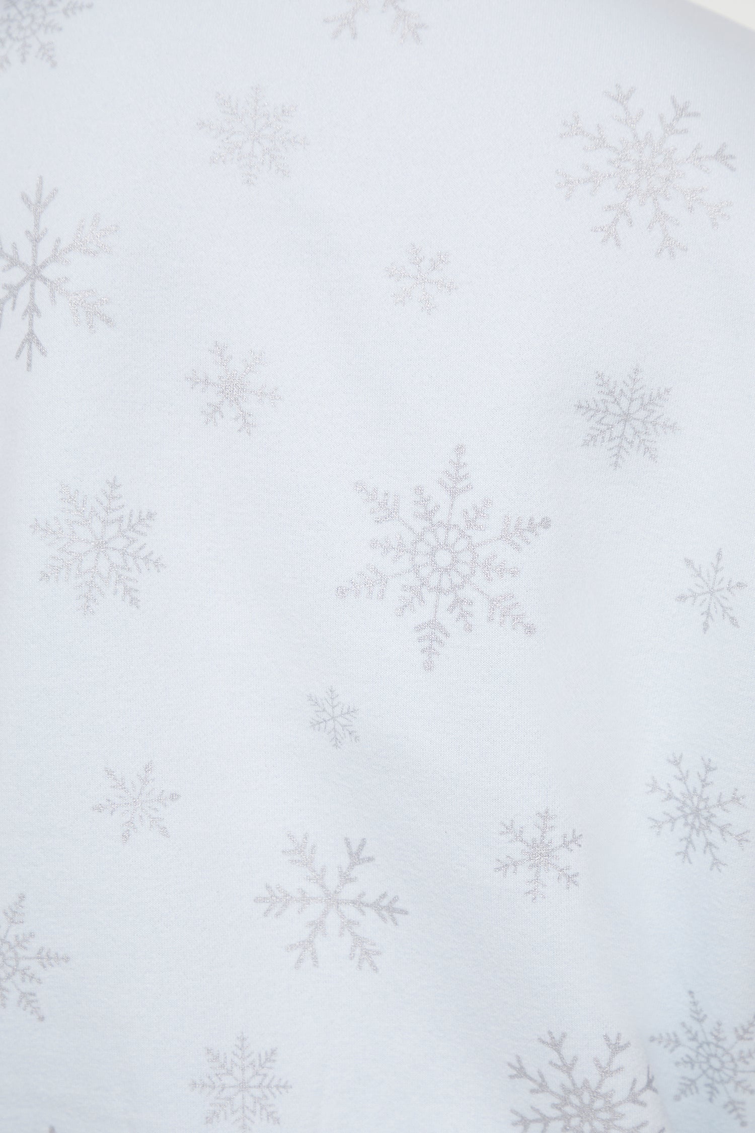 Close up of pattern of silver snowflakes on a light blue sweatshirt 