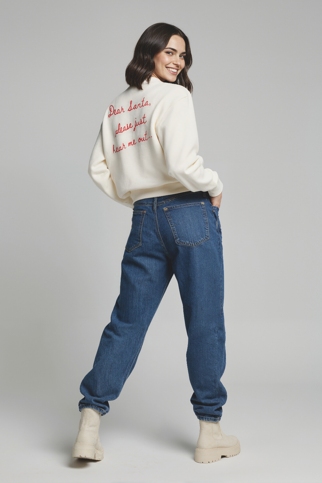 Woman wearing a white sweater with red &