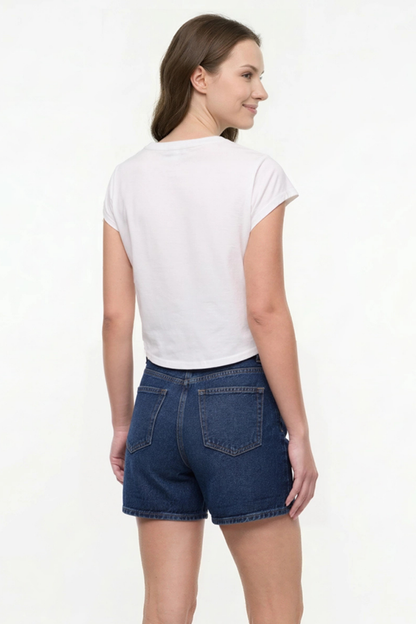 Back view of woman wearing a white t-shirt and denim shorts on a white background. 