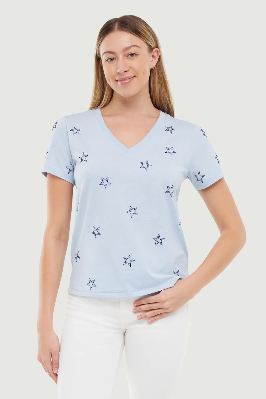 Woman wearing a light blue t-shirt with blue rhinestone star patterns on a white background