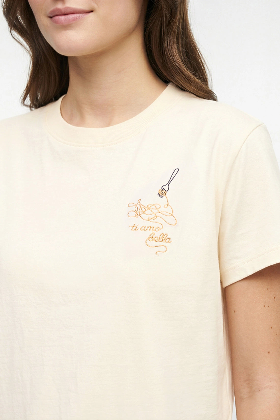 Close up view of t-shirt with embroidered design of spaghetti and a fork, accompanied by the text &