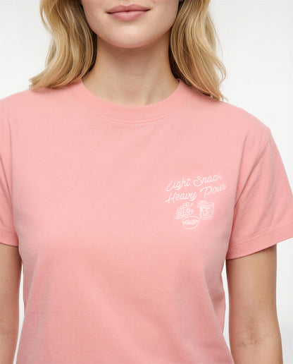 Front view of woman wearing a pale pink/red t-shirt with white &