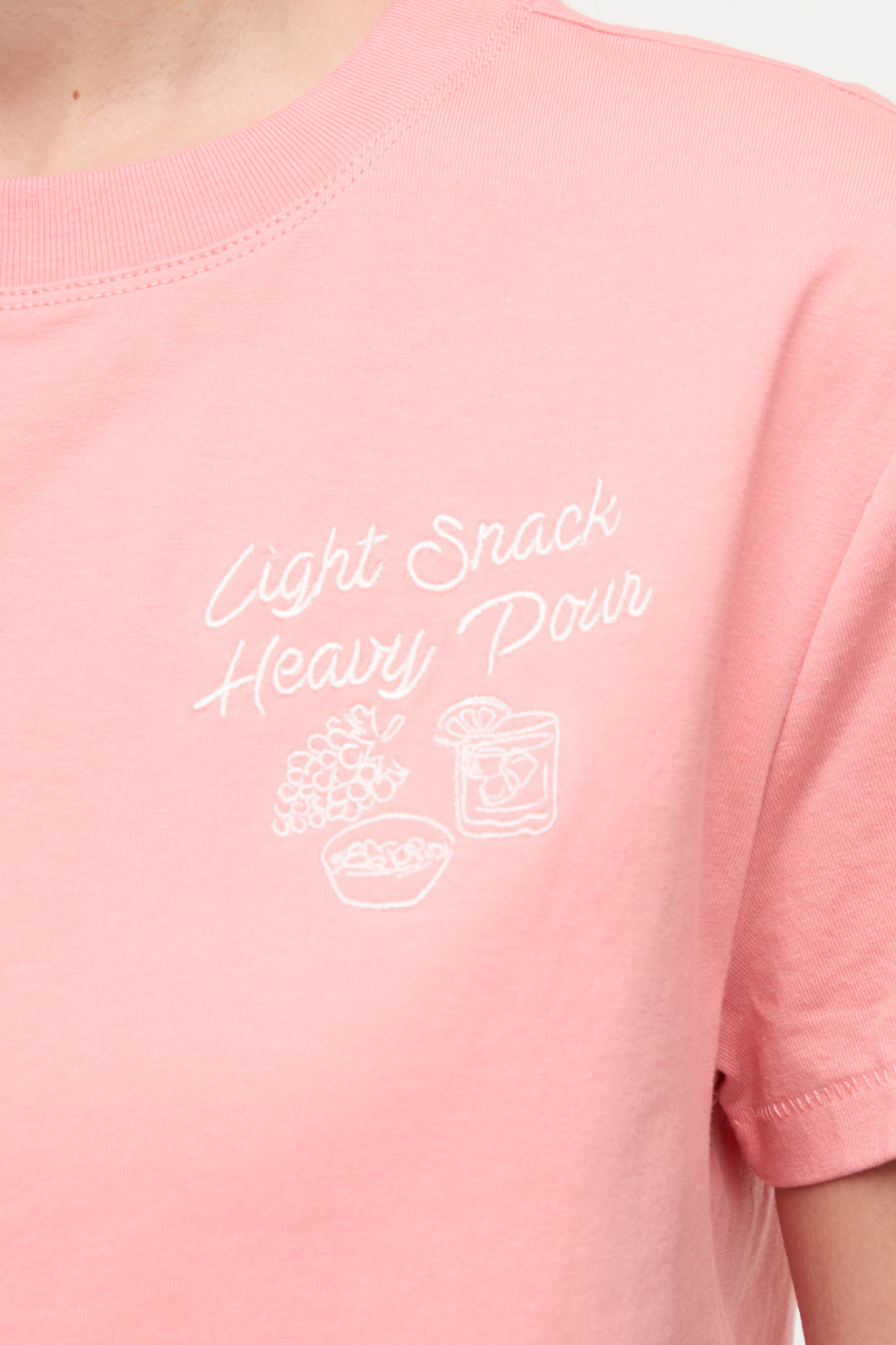 Close up view of pale pink t-shirt with white &