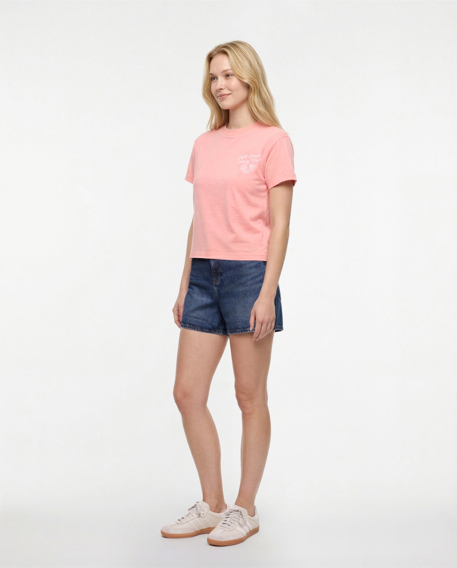Side view of woman wearing a pale pink/red t-shirt with white &